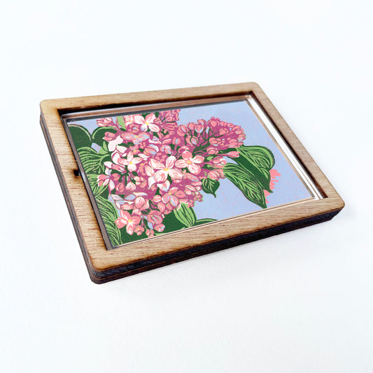 Decorative magnet featuring the block print, "Lilacs," by Peninsula Prints. The magnet has a protective clear coating and wooden frame.
