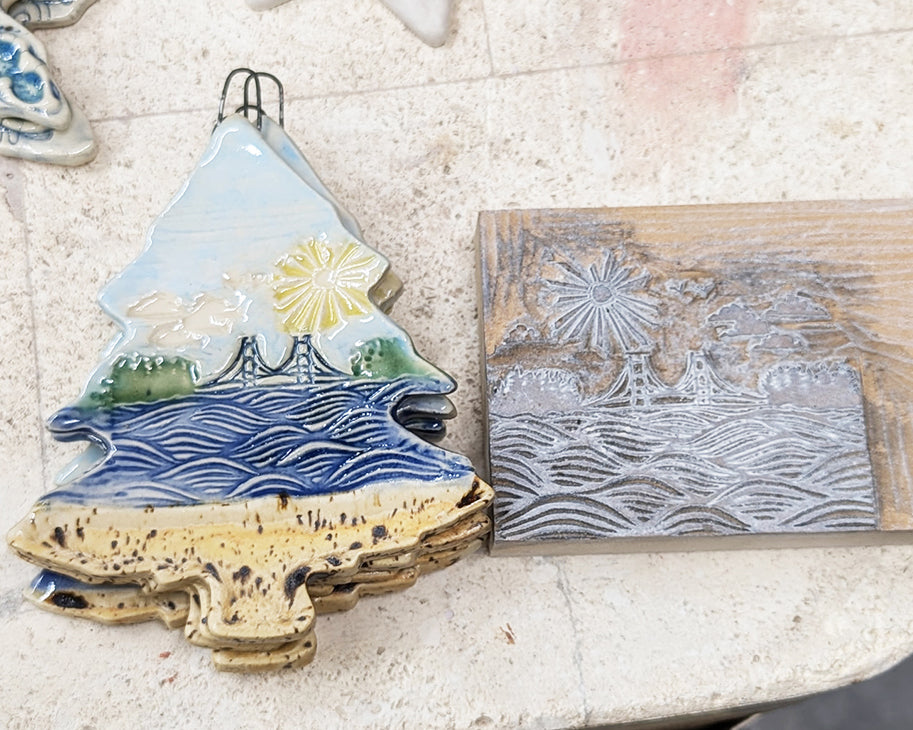 Decorative ceramic Mackinac Waves ornament next to the linoleum stamp used to create the design.