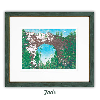 An eight-color 12" x 9" block print titled "Arch Rock" and inspired by the most iconic rock formation on Mackinac Island: Arch Rock. Framed with the Jade - Thick frame option.