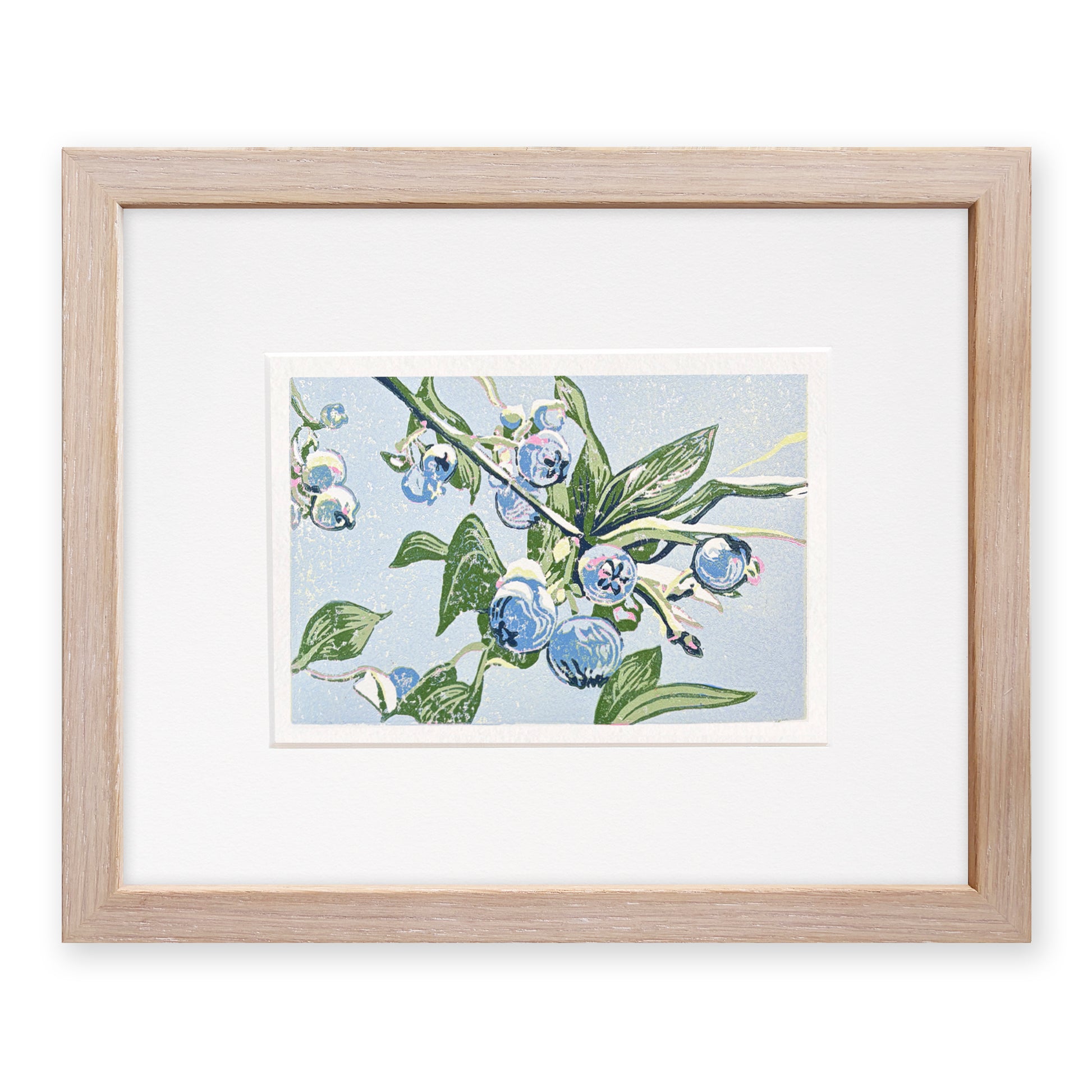Framed artwork of blueberries and green leaves on a light blue background, with a light, cerused oak frame.