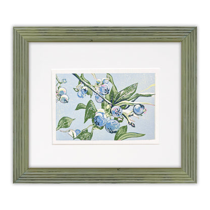 Framed artwork of blueberries and green leaves on a light blue background, with a green frame.
