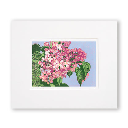 Reduction block print of blooming pink lilacs with olive green leaves against a periwinkle background. Matted in white.