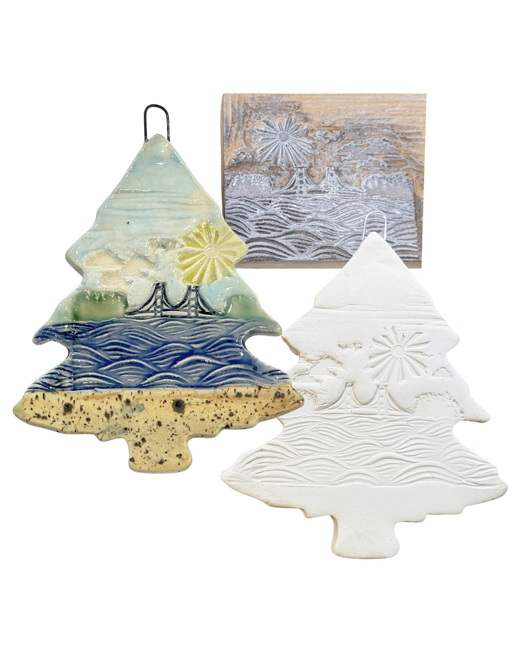 The linoleum block, and complete and in progress ceramic tree-shaped ornaments with decorative patterns on a white background.