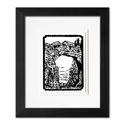 Mini Arch Rock 3"x4" one-color black and white block print of Arch Rock on Mackinac Island. Framed with a black woodgrain frame.