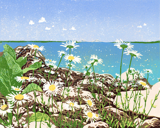 Daisy Shore is a 10" x 8" eight-color reduction block print by Natalia Wohletz of joyful daisies growing amongst limestone rocks on the Mackinac Island shore. Tucked back in the clear blue sky and turquoise water backdrop is the Mackinac Bridge.