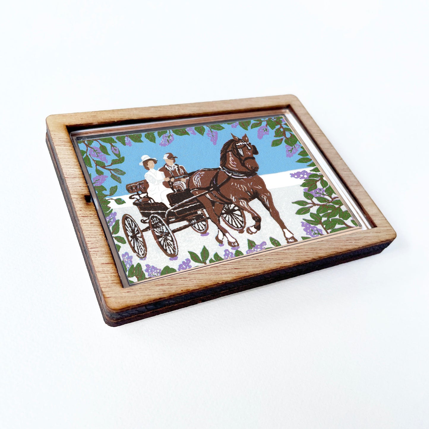 Decorative magnet featuring the block print, "Somewhere in Time Carriage Ride," by Peninsula Prints. The magnet has a protective clear coating and wooden frame.