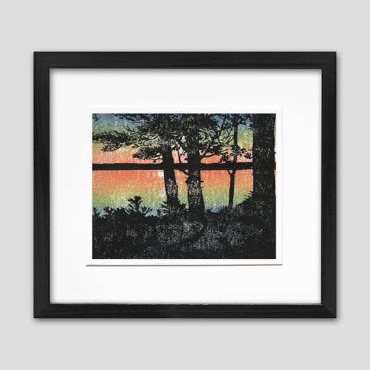 Framed lakeside living art created by Natalia Wohletz of Peninsula Prints. Sunset is a four-color linoleum block print of a warm, captivating view of a sunset over the lake. 